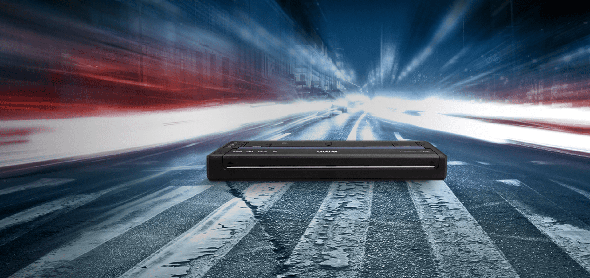 A compact Brother PocketJet 8 on a crosswalk with blurred city lights and motion in the background.