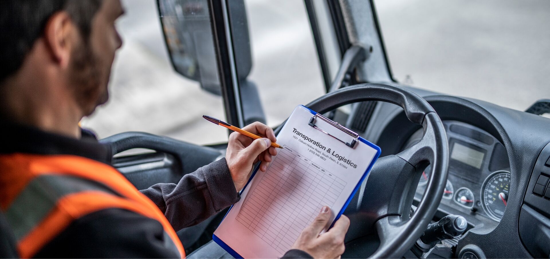 Up close Trucker filling out trucker logs in his vehicle