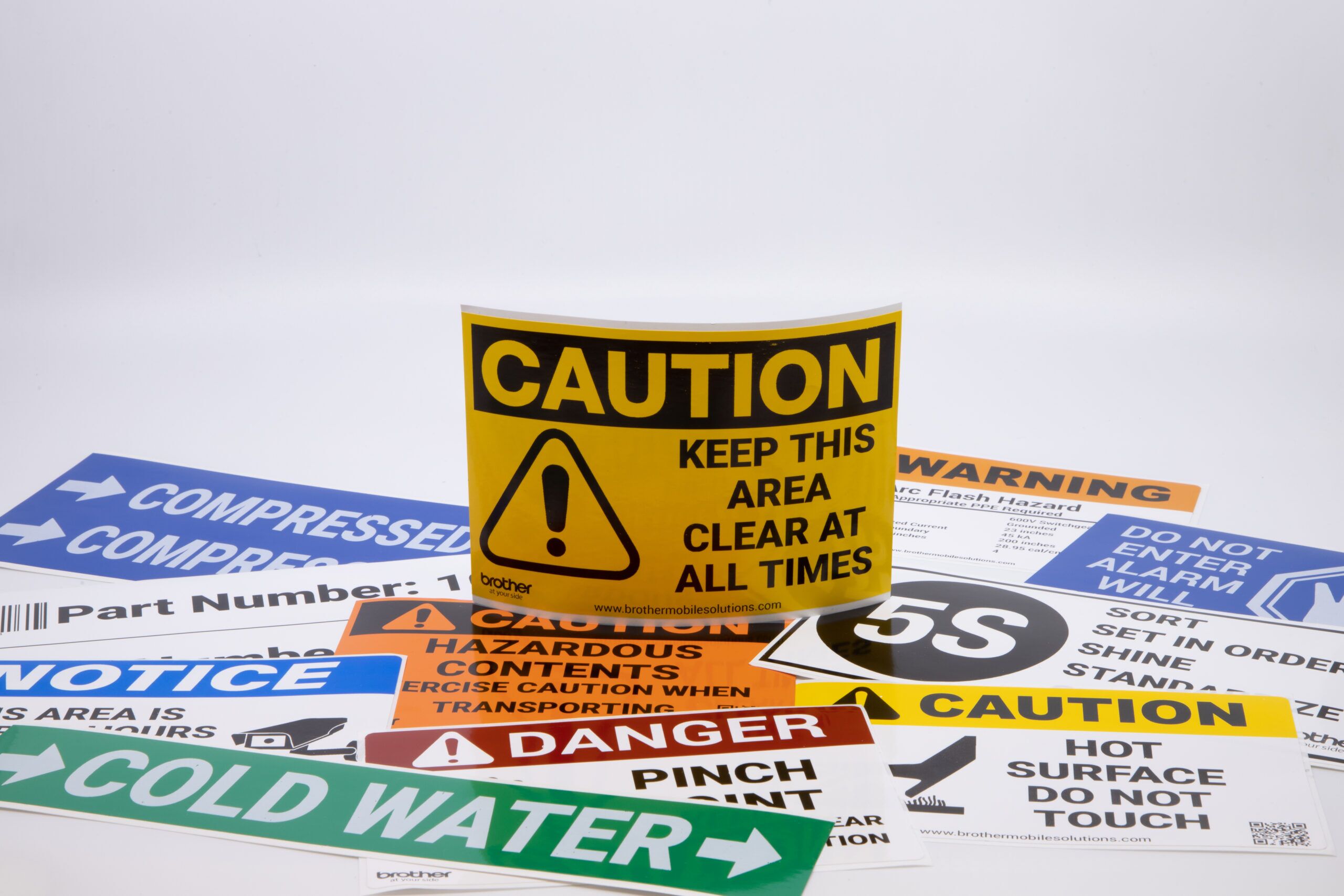 Yellow caution label standing on other safety labels
