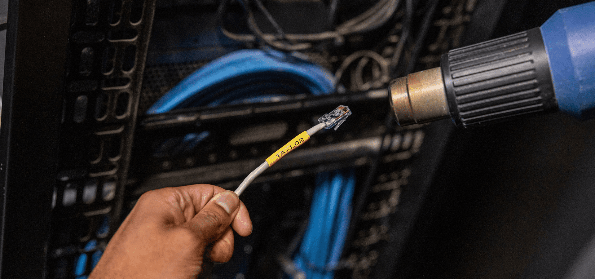 Close up of Heat gun shrinking a label to a ethernet cable