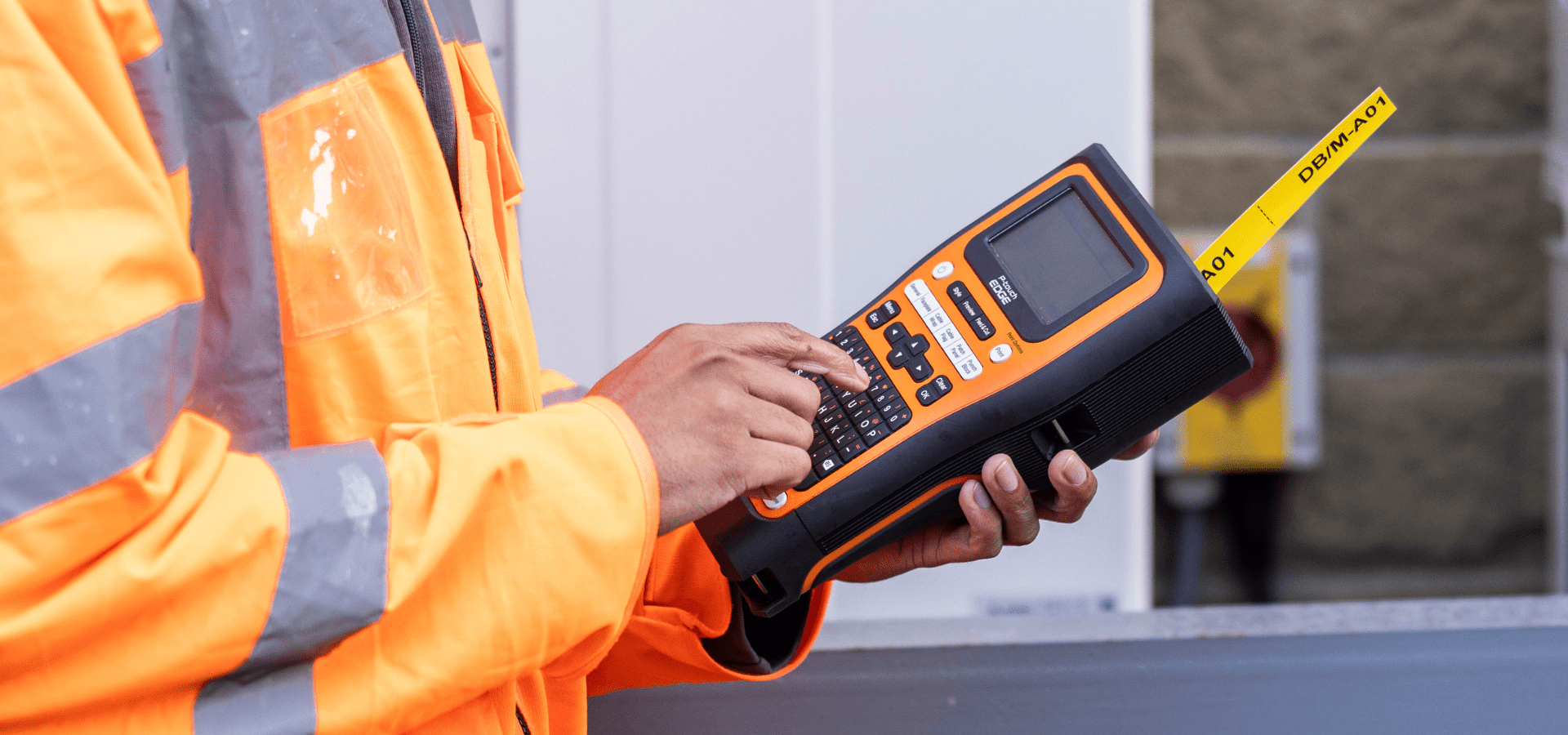 Electrician holding P-Touch Edge printing a yellow label